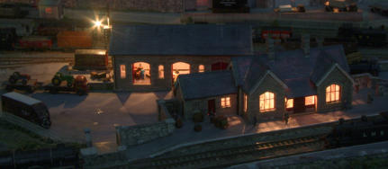 The station building and main goods shed are well lit at night.