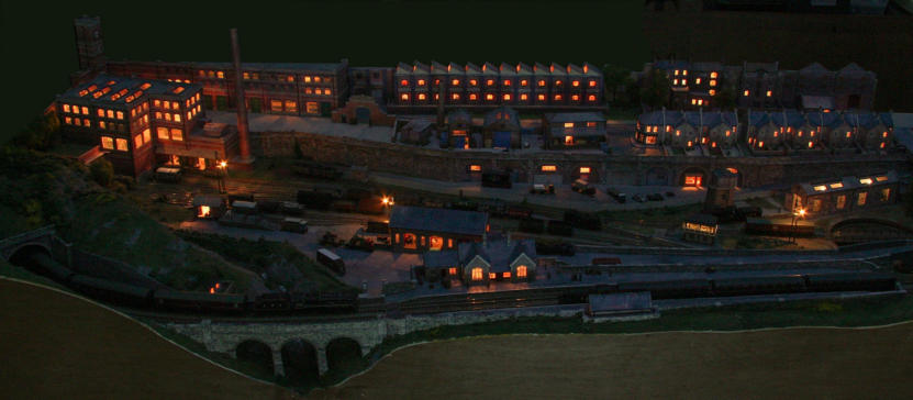 This is an overall view of Rowandale and it's goods yard lit up at night. There is just enough light from an overcast moon to be able to see the viaduct and other features.